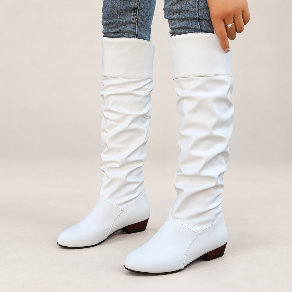 Women's slouch knee-high boots on a light neutral background
