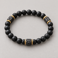 Marek elastisches Herrenarmband mit mattschwarzen Perlen und goldfarbenen Details