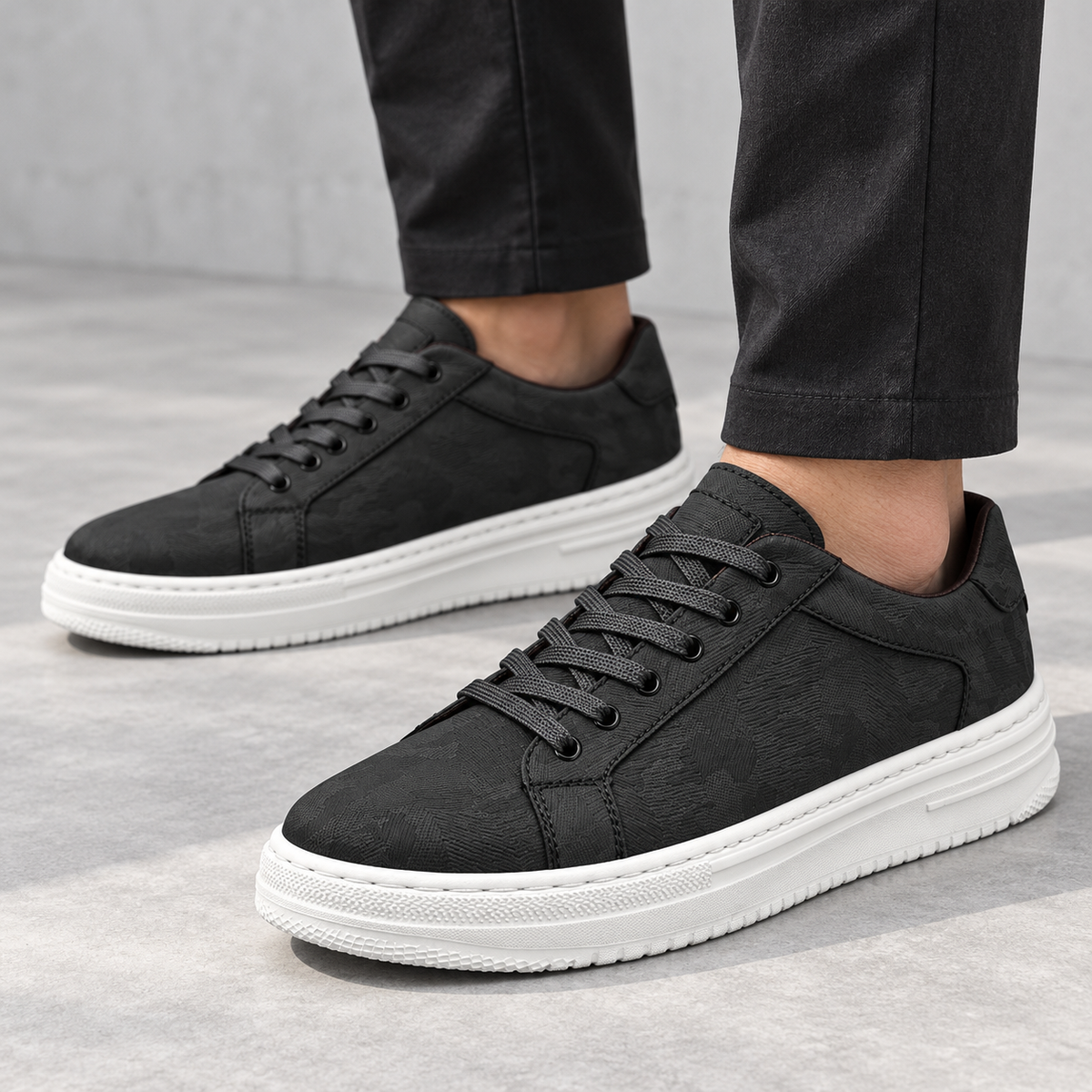 Men's black low-top lace-up trainers with panelled upper and white sole