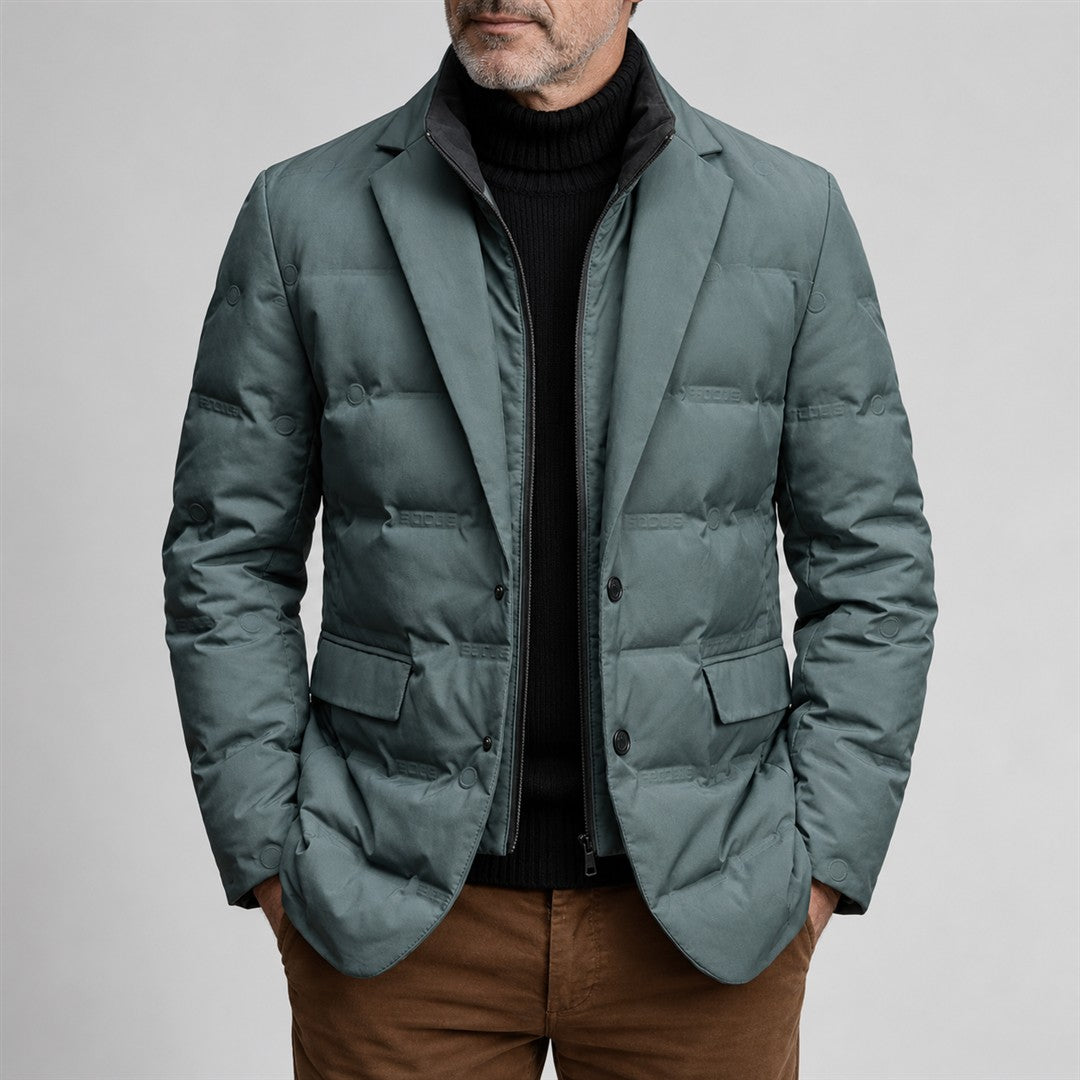 Teal-grey quilted jacket with lapels worn by a mature man against a light grey background